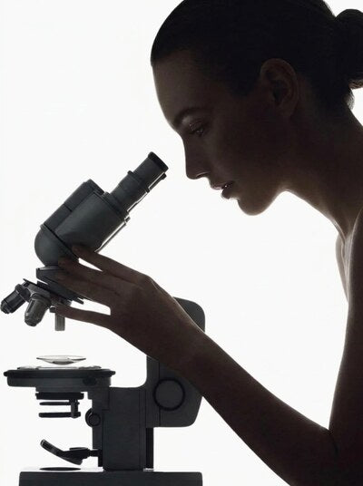 A clinician looking into a microscope